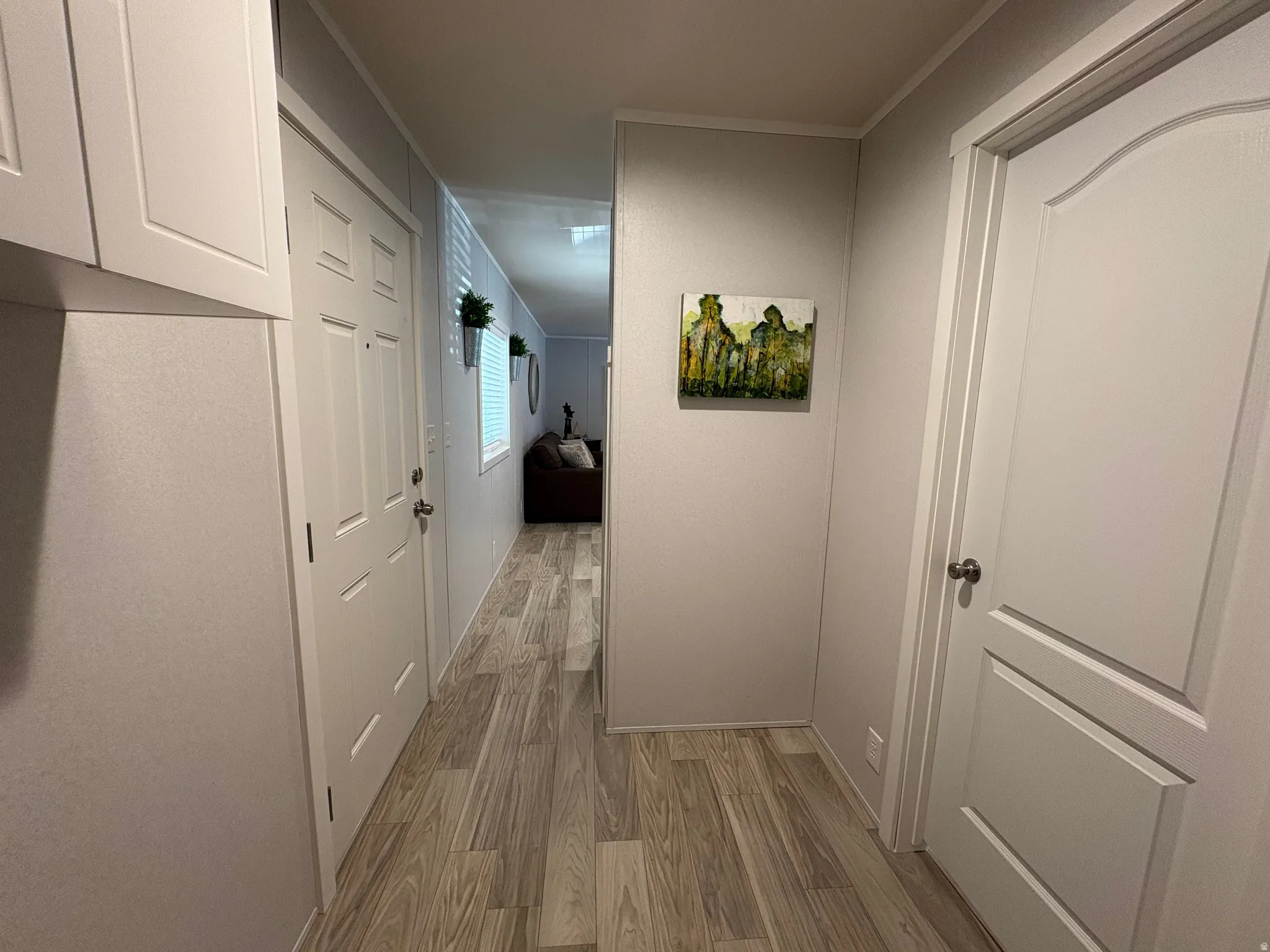 Light wood-finish flooring extending through the hallway
