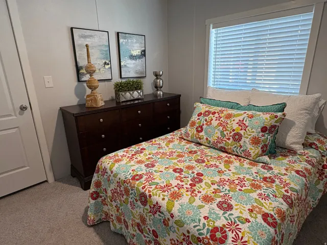 Light gray wall color, textured carpet, white window trim, horizontal blinds, white door with brushed nickel hardware