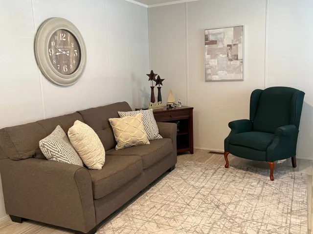 Wall paneling, wood-finish flooring, and a dark wood-finish end table