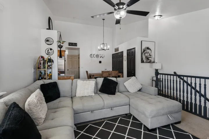 Vaulted ceilings with a ceiling fan, recessed lighting, and a chandelier
