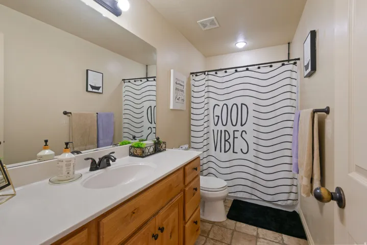 Bathroom featuring a vanity with a rectangular sink, wood cabinetry, and a full-width mirror