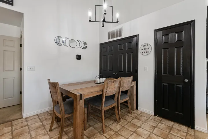 Checkerboard floor tiles, white walls, and a black paneled door