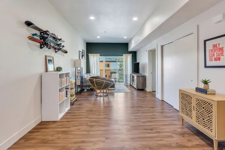 Recessed lighting, wood-finish flooring, and a private balcony
