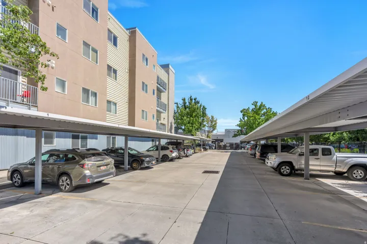 Covered parking structure with concrete paving and multi-level building