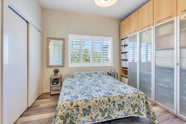 Wood-finish flooring, plantation shutters, and a ceiling-mounted light fixture
