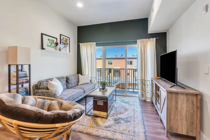 Sliding glass door opening to a private balcony with black metal railings