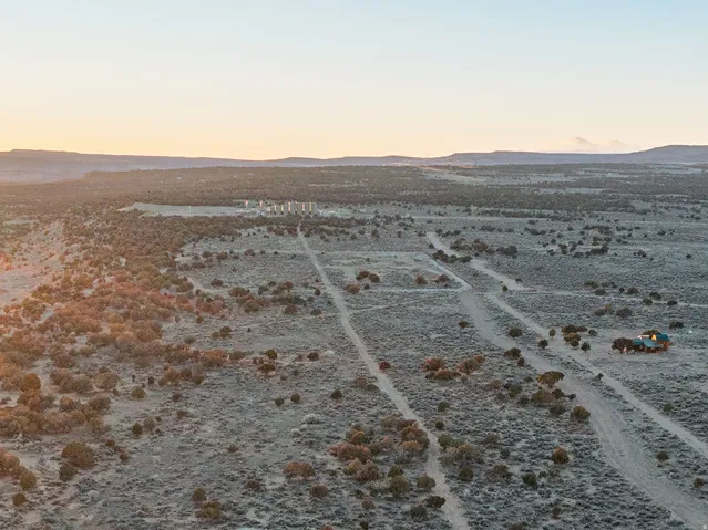 Expansive desert landscape featuring natural vegetation and distant mountain ranges