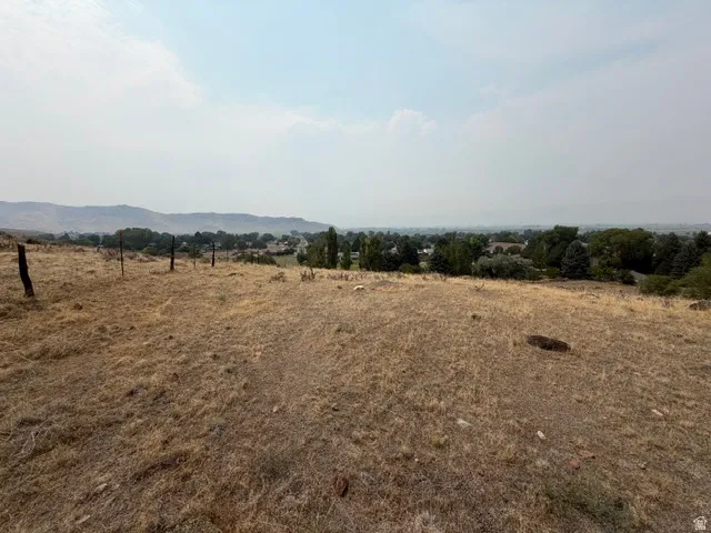 Expansive open terrain with natural vegetation and distant community elements