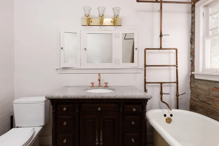 White vanity cabinet with a speckled countertop and an undermount sink