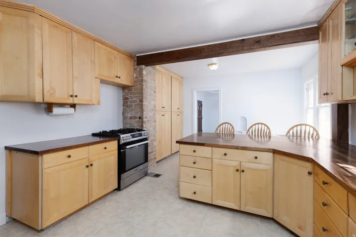 Wood-finish cabinetry and countertops with a stainless steel range