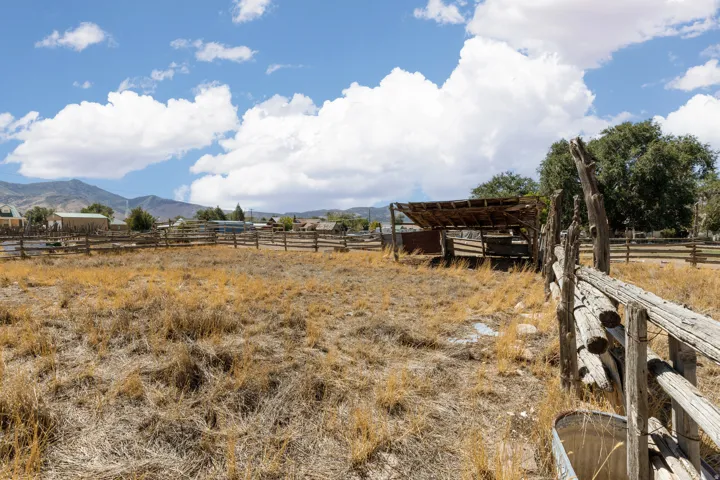 Expansive open lot with a rustic wooden fence and an outbuilding