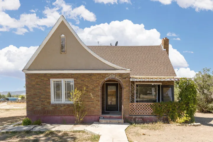 Brick exterior with a stucco gable, arched entryway, and a covered porch