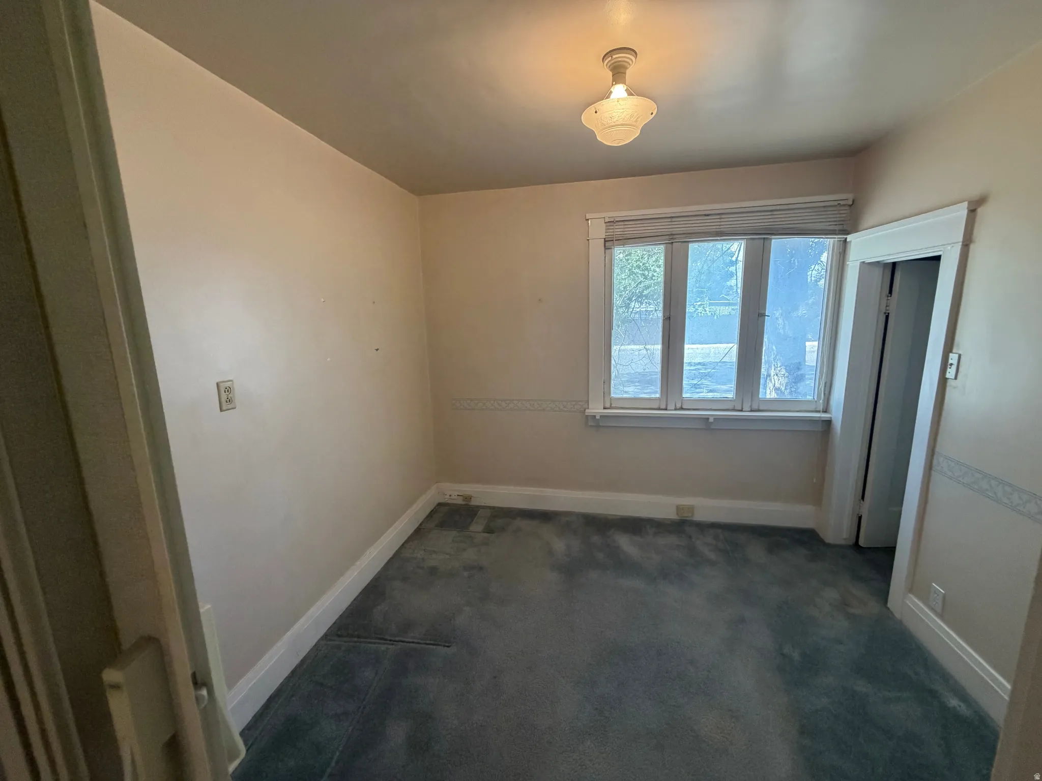 Recessed window with white trim, a flush mount ceiling light fixture, and carpeted flooring
