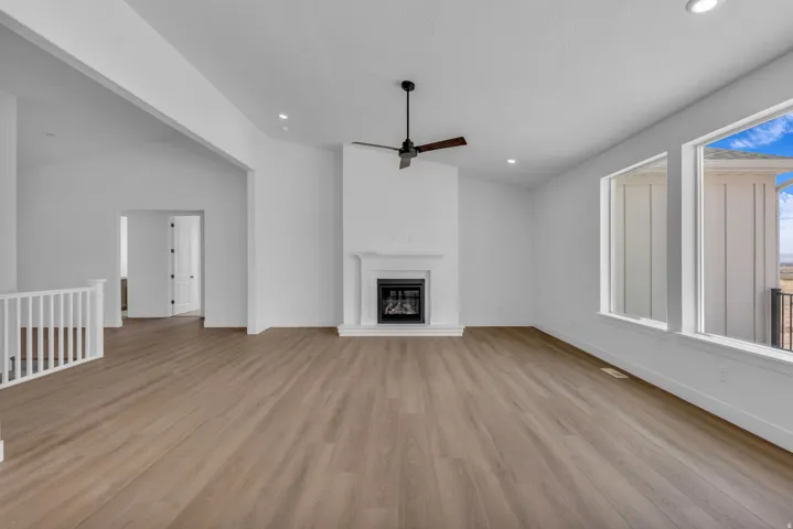 Open-concept great room with a gas fireplace and beautiful wood and tile surround and mantle, vaulted ceilings on entire main floor.