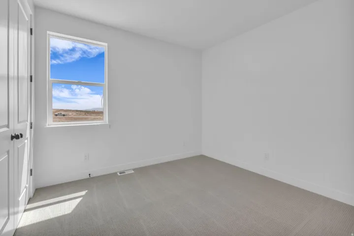 Large bedroom with vaulted ceiling with beautiful views of open space to the south.
