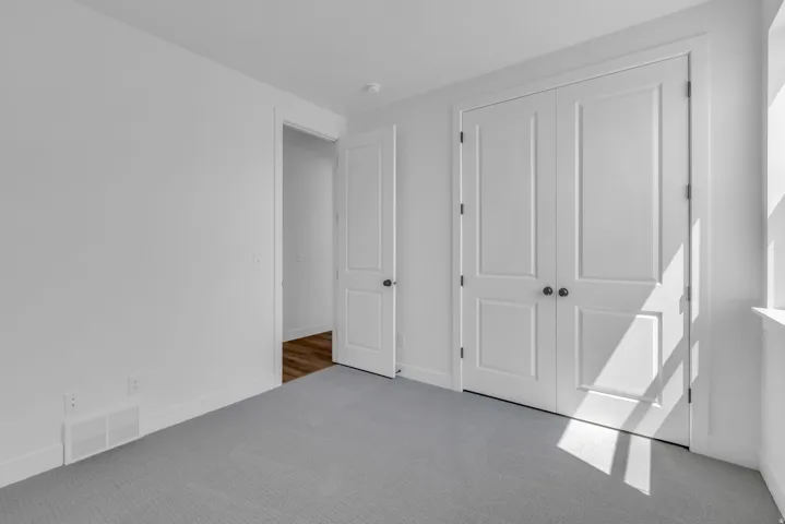 Large vaulted bedroom with double paneled closet doors.