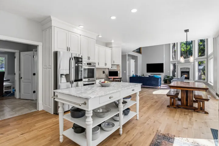 Kitchen featuring white cabinetry, stainless steel appliances, and a central island with a stone countertop