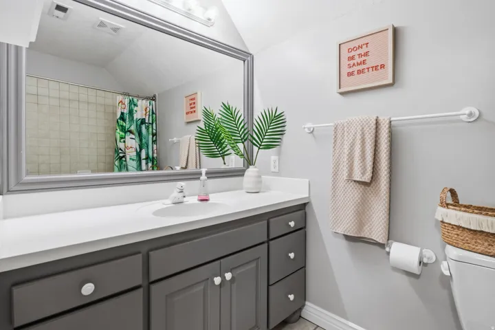Vanity with integrated sink, light-toned countertop, and gray cabinetry