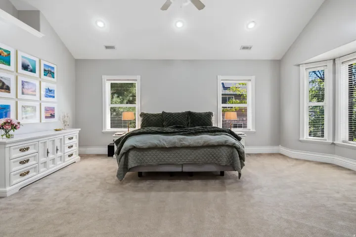 Vaulted ceiling with recessed lighting, ceiling fan, and carpeted flooring