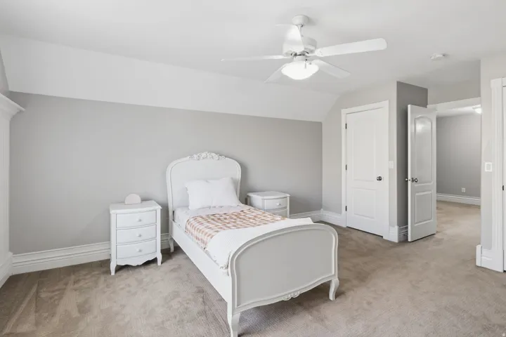Carpeted flooring, vaulted ceiling, and white ceiling fan with integrated lighting