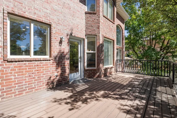 Expansive outdoor deck with a dark wood-finish surface and black metal railing