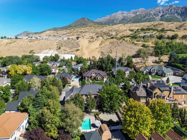 Neighborhood setting with mature trees and mountain backdrop