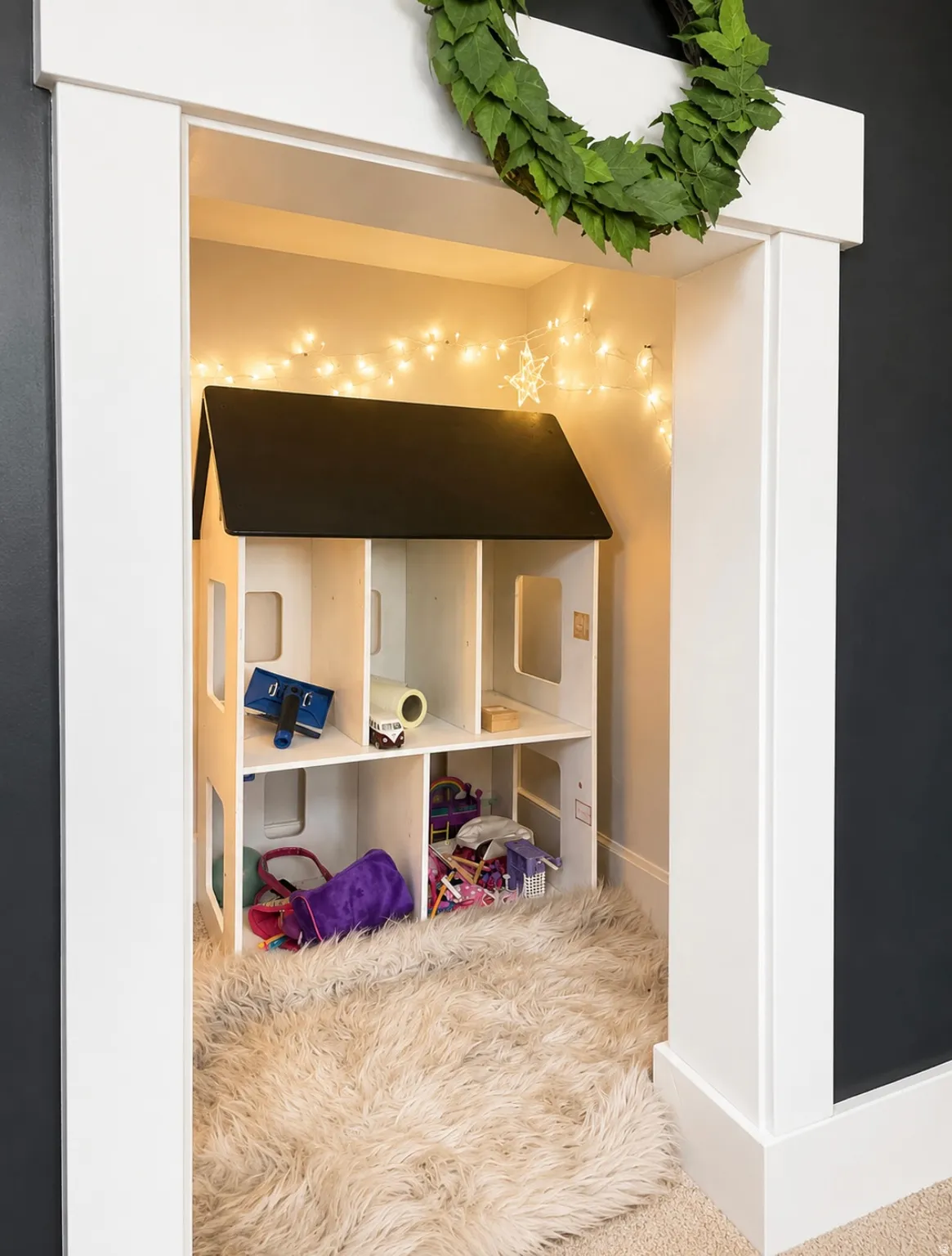 Carpeted niche featuring white trim, dark wall paint, and string lighting
