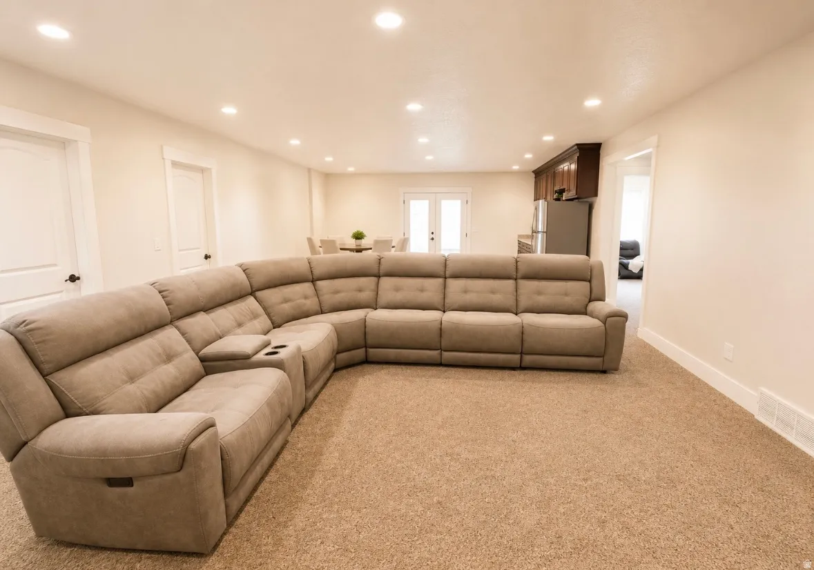 Spacious open-concept room featuring recessed lighting, light-toned walls, and plush carpeting