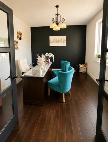 Dedicated office space featuring dark wood-finish flooring and a contrasting accent wall