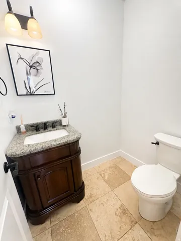 Wood-finish vanity with granite countertop and integrated sink