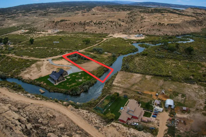 Riverfront property featuring a clear natural river, surrounding green foliage, and natural landscape