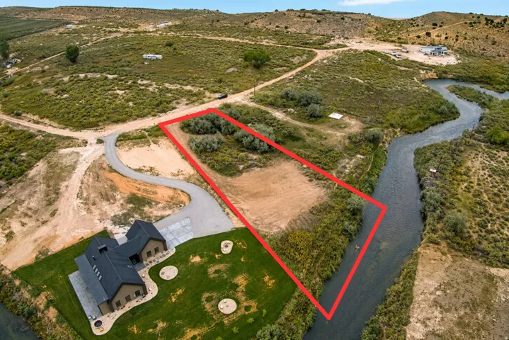 Expansive acreage featuring a winding river, mature trees, and a gravel driveway