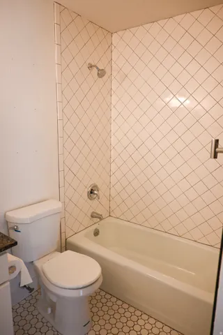 Bathroom featuring a white bathtub, chrome fixtures, and a toilet