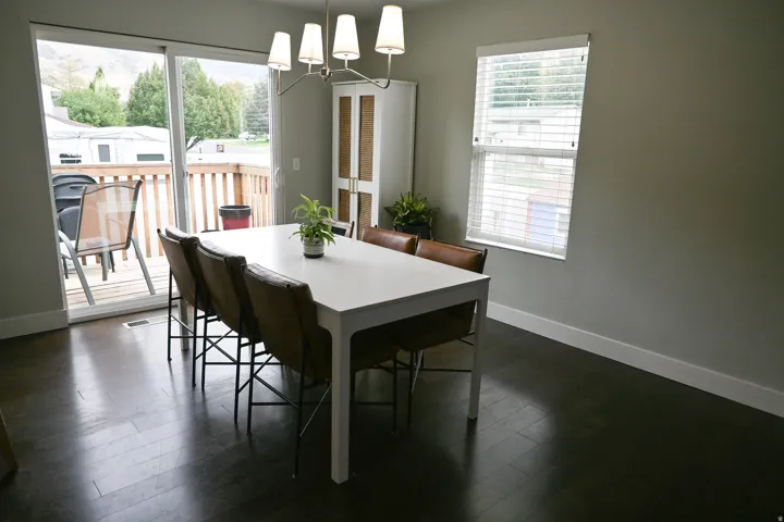 Dark wood-finish flooring, sliding glass door, recessed window, contemporary chandelier, and built-in storage cabinet