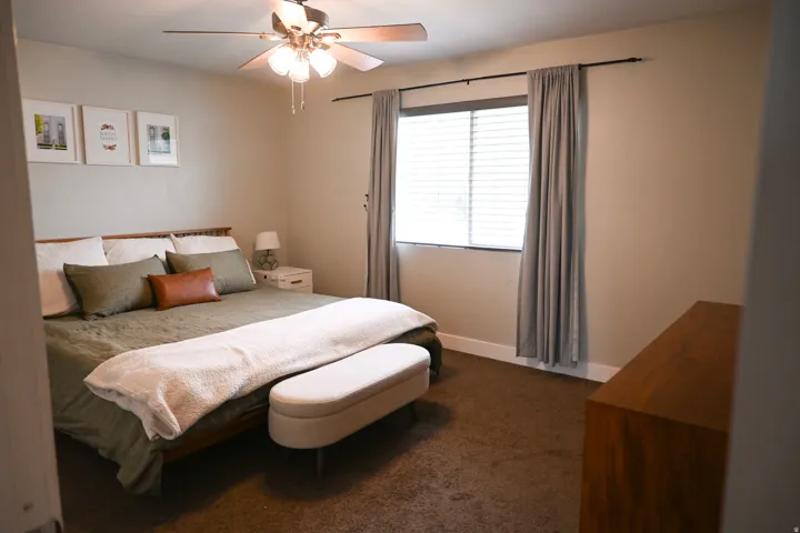 Recessed window with horizontal blinds, overhead ceiling fan with lighting, and dark brown carpeting