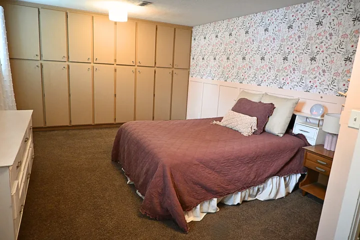 Wall-to-wall built-in cabinetry, wall paneling, and patterned wallpaper