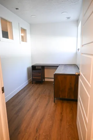 Wood-finish flooring, recessed lighting, and white walls