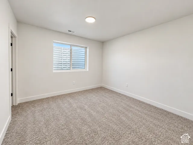 Recessed window with a window well, light-toned carpeting, white walls, and a ceiling-mounted light fixture