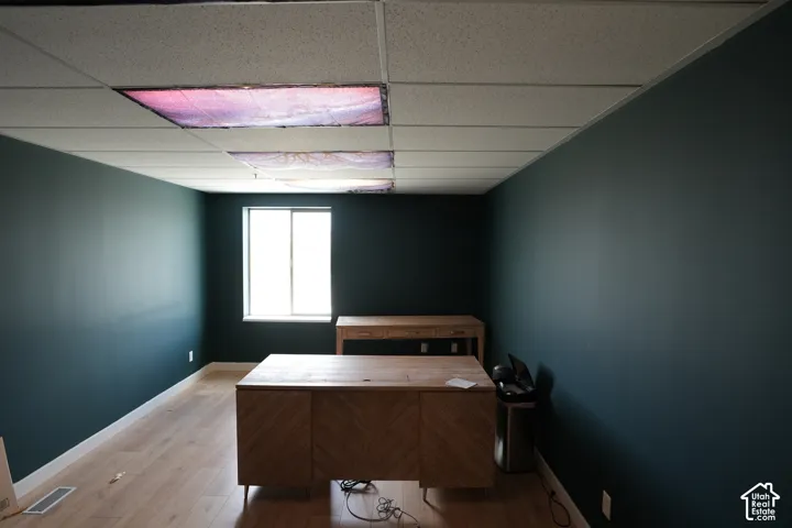 Recessed lighting, drop ceiling, wood-finish flooring, and a large window