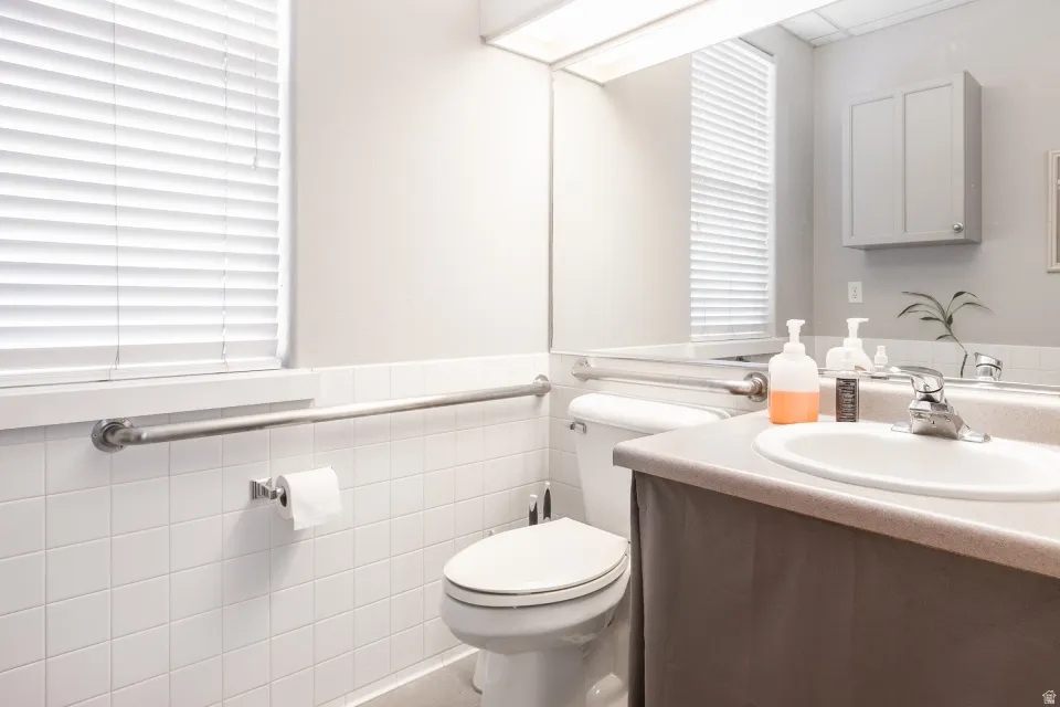 White tile wainscoting and a built-in grab bar