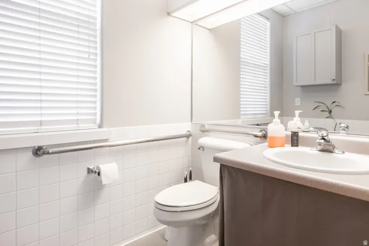 White tile wainscoting and a built-in grab bar