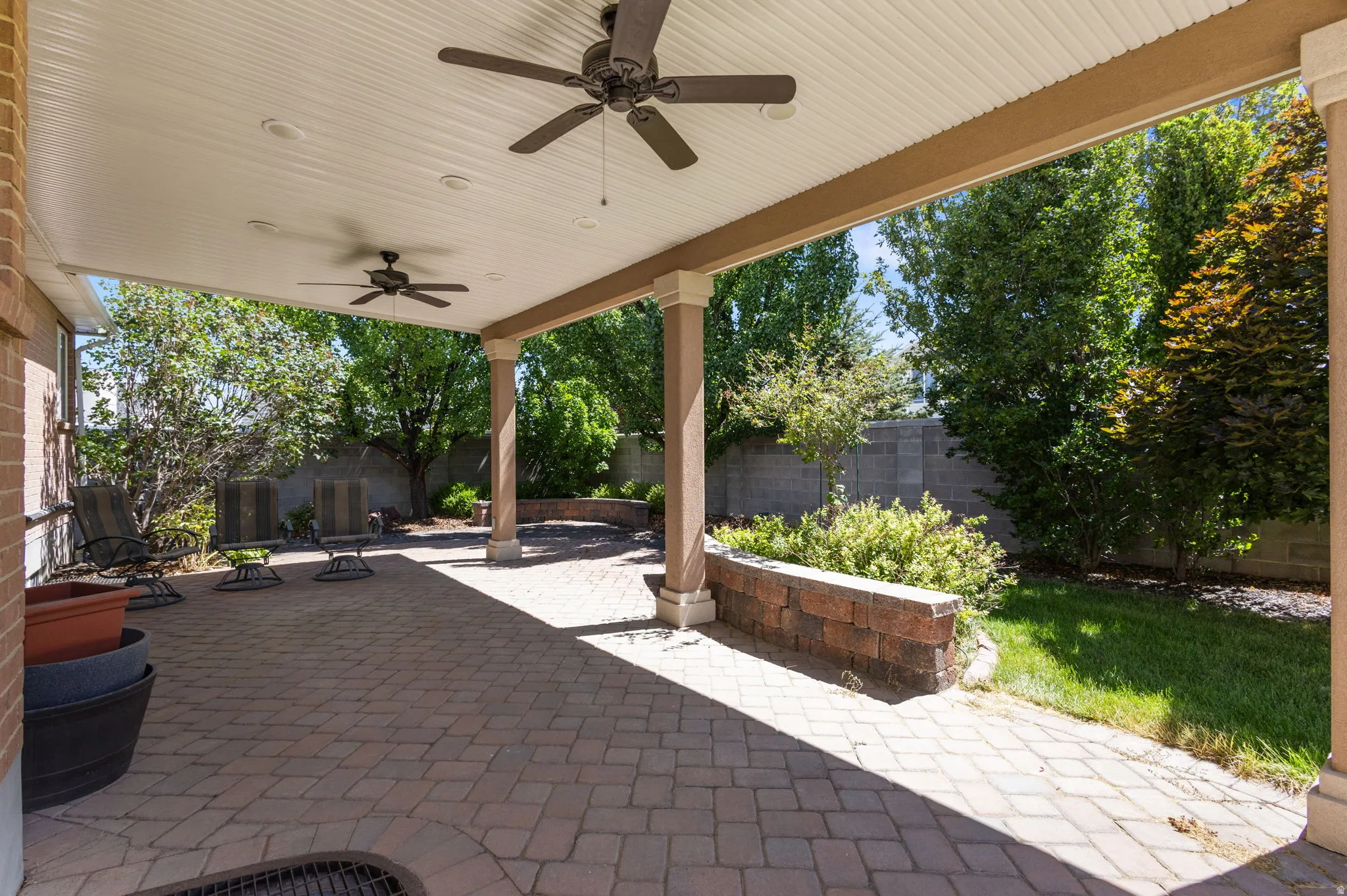 Covered patio featuring paver flooring, two ceiling fans, and recessed lighting