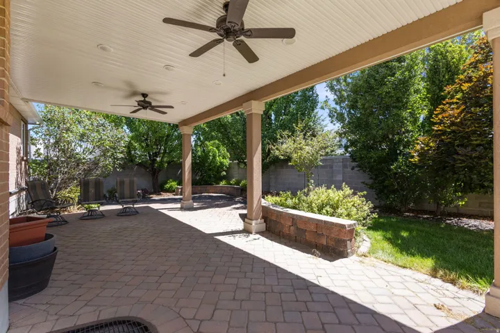 Covered patio featuring paver flooring, two ceiling fans, and recessed lighting