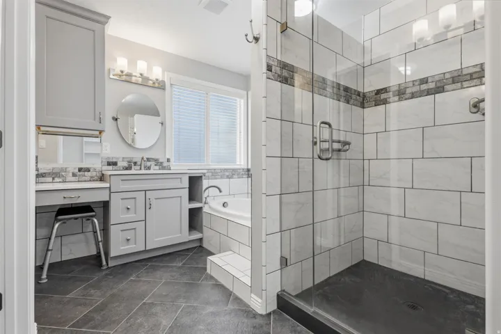 Modern walk-in shower with glass enclosure, subway tile surround, and decorative tile accent band