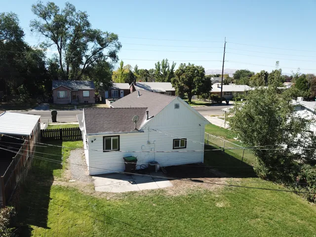 Gabled roofline, white siding, and a partial chain-link fence