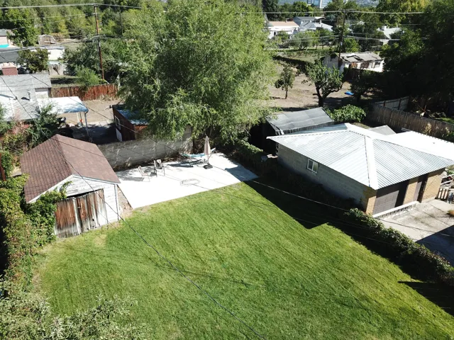 Expansive green lawn with a detached auxiliary building and a separate structure with a metal roof