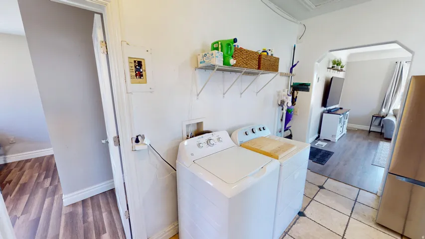 Laundry area with tile flooring and wall-mounted shelving