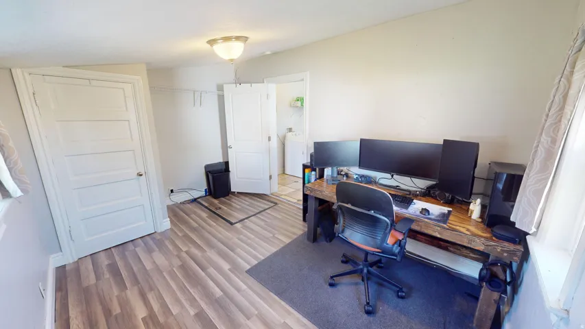 Wood-finish flooring throughout, white paneled doors, and a ceiling-mounted light fixture