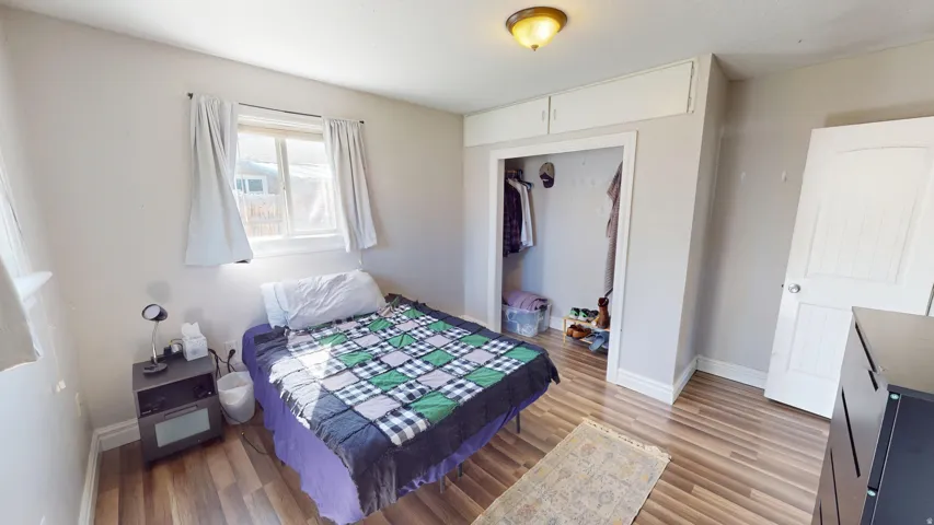 Wood-finish flooring, built-in overhead cabinetry, and an interior door with a paneled design