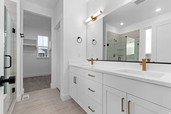 Dual vanity with brass fixtures and white countertops